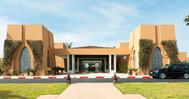 Terracotta-coloured entrance to Hotel Riu Tikida Palmeraie, with arched panels and a covered doorway