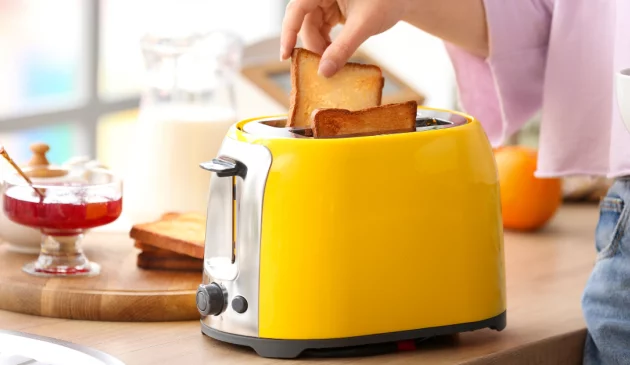 Woman grabbing toast out of toaster