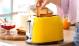 Woman grabbing toast out of toaster