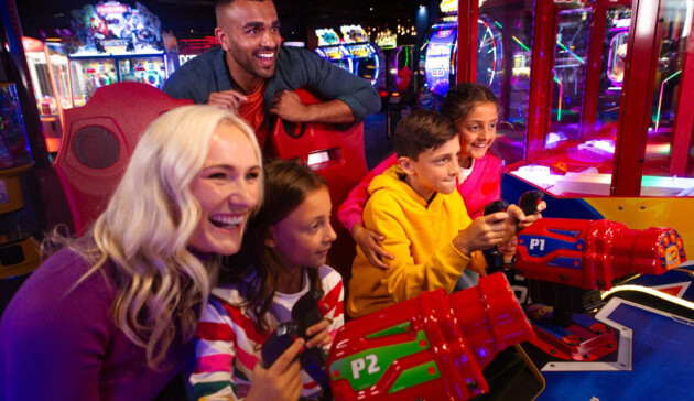 A happy family playing on an arcade game at Hollywood Bowl