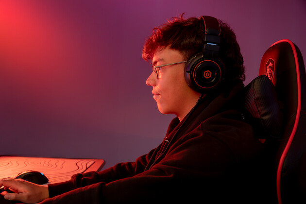 A preteen is playing on his computer in a gaming chair