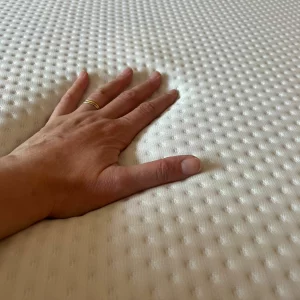 A hand feels the Emma Hybrid Thermosync mattress