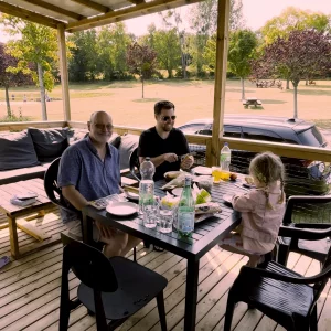 A family sitting on a veranda at Eurocamp La Vallee