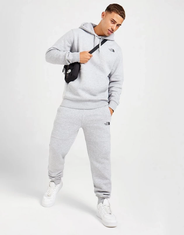A male model wearing The North Face Overhead Fleece Tracksuit from JD Sports