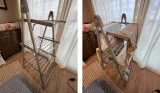 Two portrait pictures of the John Lewis 3-Tier Heated Clothes Airer. The left shows the airer set up in a room with wooden flooring, standing next to a long window covered by a sheer white curtain. The first picture shows the airer with nothing hanging on it. The second image shows the airer covered with various items of white, grey and beige coloured clothing.