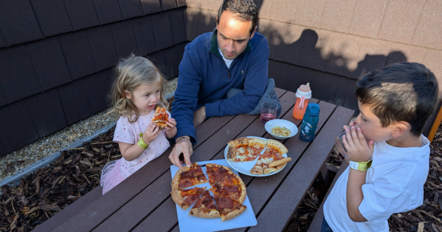 A family eating pizza at Knights Retreat Lodges at Leeds Castle