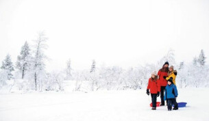 Family posing for a photo in the snow in Lapland