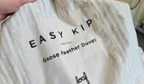 A close up of the Easy Kip Goose Feather Duvet by Loaf's packaging