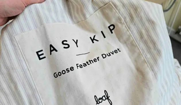 A close up of the Easy Kip Goose Feather Duvet by Loaf's packaging