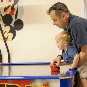 A father and son enjoying a game of air hockey at Luccombe Hall Hotel in the Isle of Wight