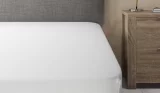 a bed with a white cooling bed sheet