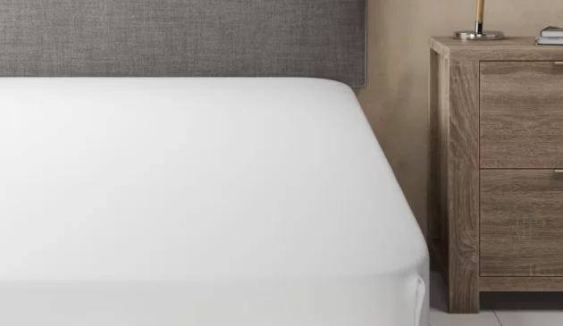a bed with a white cooling bed sheet