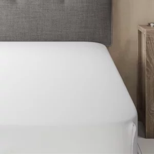 a bed with a white cooling bed sheet