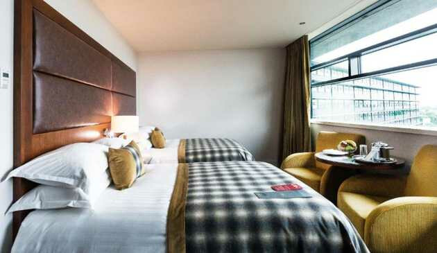 A big bed facing a window in a room at Macdonald Manchester hotel