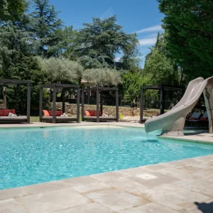 A view of the main pool and sunbeds and slide at Country Kids in the South of France