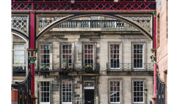 the facade of a grand hotel through a red arch