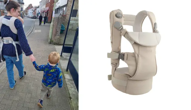 Mum wearing Mamas & Papas Kudo Baby Carrier while holding child's hand