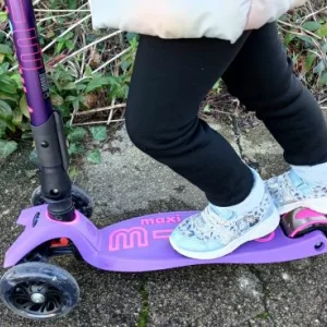 A close up of a child using the brake on the Maxi Micro Scooter
