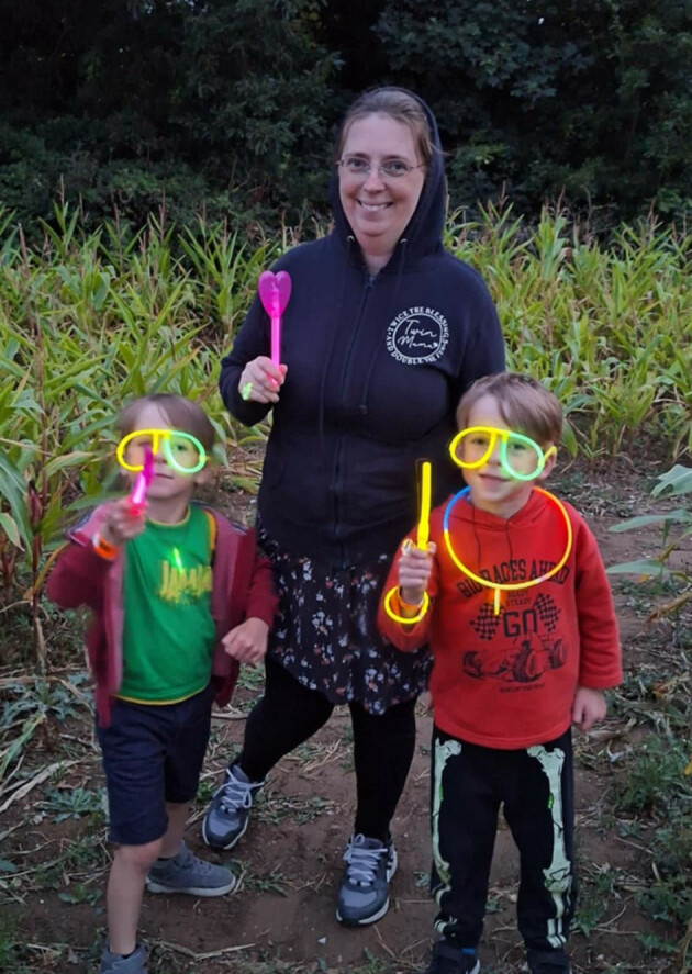 Mum Joanna and her two boys with glow sticks while outside