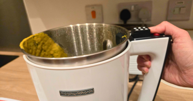 Hand holding Morphy Richards soup maker stainless steel jug showing internal heating element