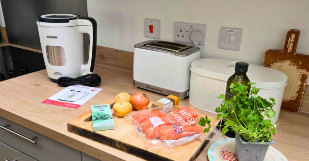 White Morphy Richards soup maker with Russell Hobbs toaster and fresh ingredients including British carrots on kitchen counter