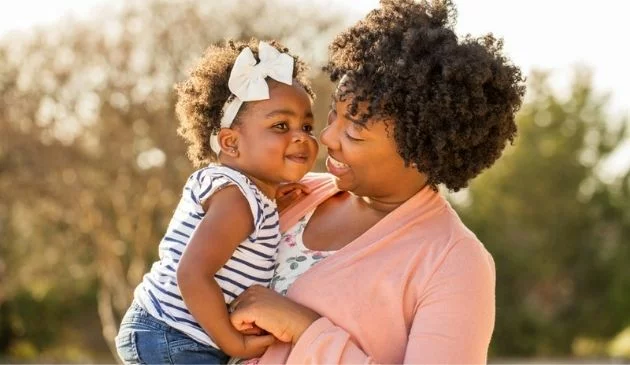 mother outside with daughter in her arms