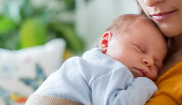 Newborn sleeping on mother