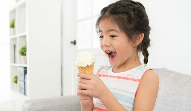 Child with an ice cream on a sofa
