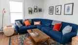 A living room with a blue corner sofa and colourful cushions