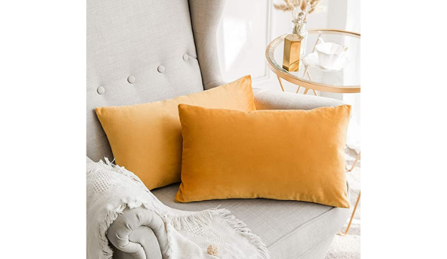 two mustard coloured cushions on an off-white chair