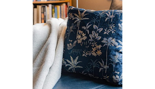 A blue cushion with a rainforest pattern on a blue leather chair