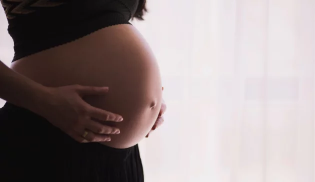 a woman's pregnant belly, she's wearing comfortable black clothing