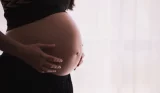 a woman's pregnant belly, she's wearing comfortable black clothing