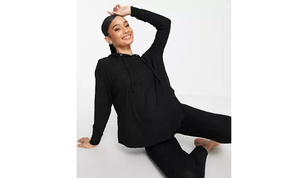 a pregnant woman posing in a black hoodie and leggings
