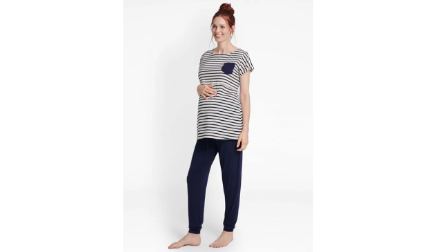 a pregnant woman posing in stripy pyjamas