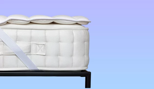 A mattress with a cooling mattress topper against a blue background