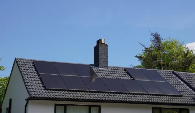 A house with solar panels on the roof in the sunshine in the UK