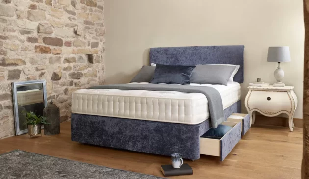 A bed in a bedroom with wooden flooring