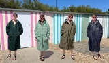 Mumsnet journalist Poppy O'Neill in a selection of changing robes with a beach hut background