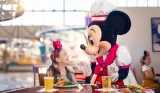 a girl looks in wonder at Minnie Mouse