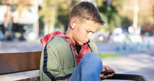 a teenage boy looking at a smartphone
