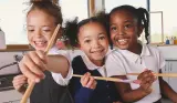 Three children wearing NEXT back to school clothing