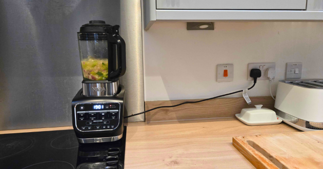 Ninja Foodi Blender and Soup Maker positioned under kitchen wall cupboards during soup cooking