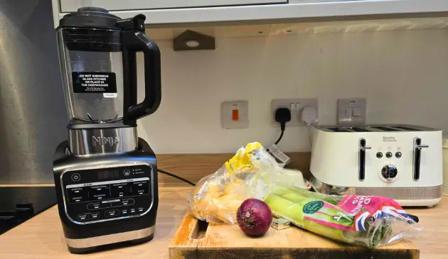 Ninja Foodi Blender and Soup Maker next to soup ingredients on a chopping board