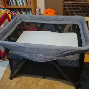 Nuna Sena Aire travel cot pictured in testing adapted for newborn