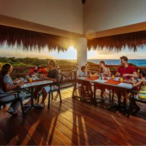 A family eating on the outdoor dining terrace at the Occidental at Xcaret Destination in Mexico