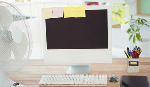 Office desk with computer and fan