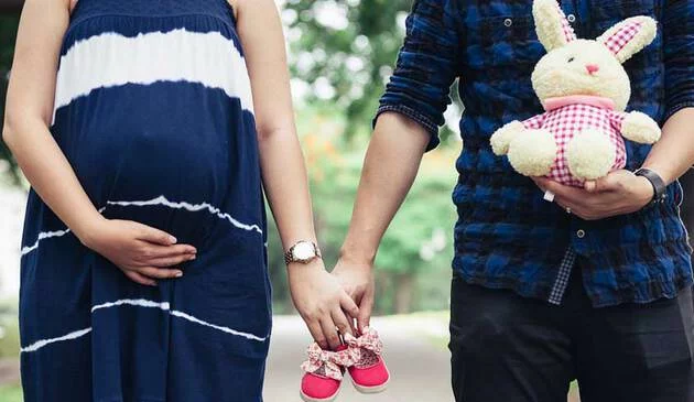 man holding hands with pregnant woman