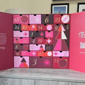 Open OK! Beauty Advent Calendar with two pink doors and 25 numbered drawers in berry, burgundy and gold