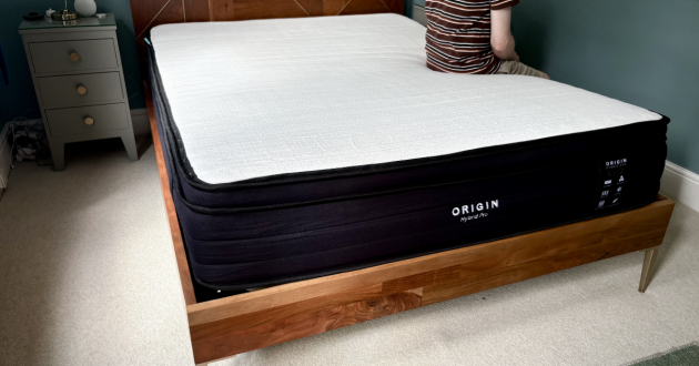 Someone sitting on the Origin Hybrid Pro Mattress